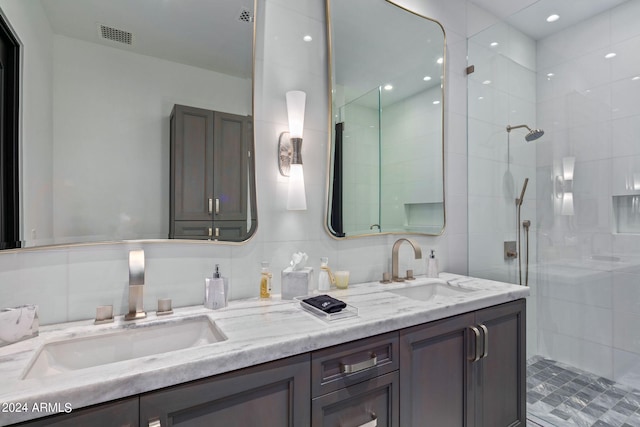 bathroom with walk in shower, backsplash, tile walls, and dual bowl vanity