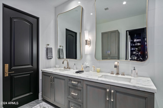 bathroom featuring dual bowl vanity, tile flooring, and tasteful backsplash