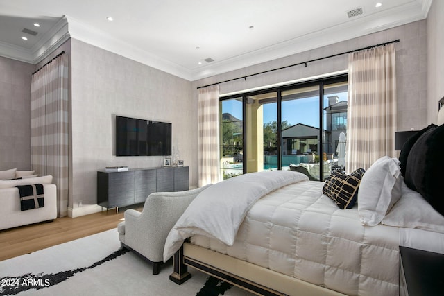 bedroom featuring light hardwood / wood-style floors, crown molding, and access to exterior