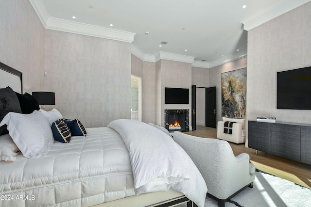 bedroom with light hardwood / wood-style floors, crown molding, a fireplace, and tile walls