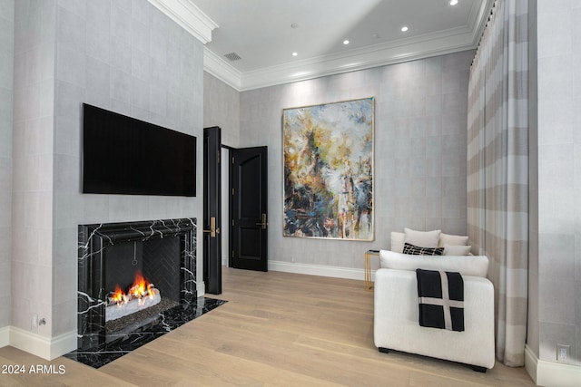 interior space with crown molding, a tile fireplace, and light wood-type flooring