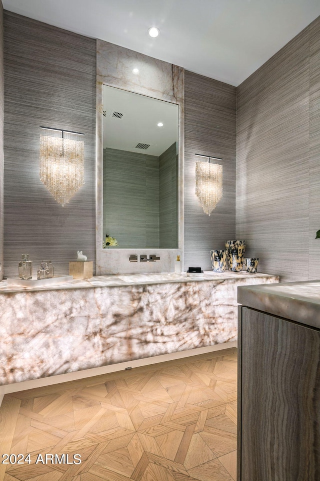 bathroom with tile walls, vanity, and a chandelier