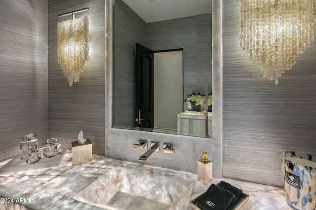 bathroom featuring tile walls, vanity, and a chandelier