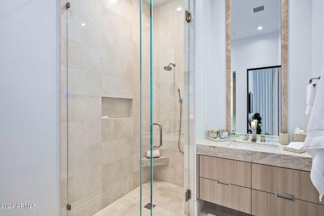 bathroom with a shower with door and vanity