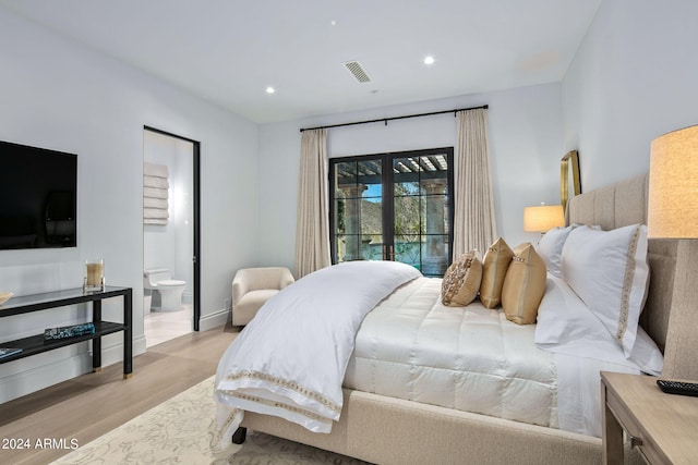 bedroom featuring light hardwood / wood-style flooring, connected bathroom, and access to outside