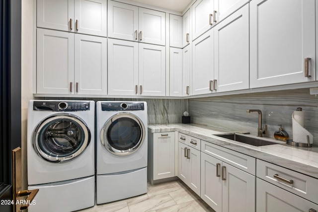 washroom with cabinets, sink, separate washer and dryer, and light tile flooring