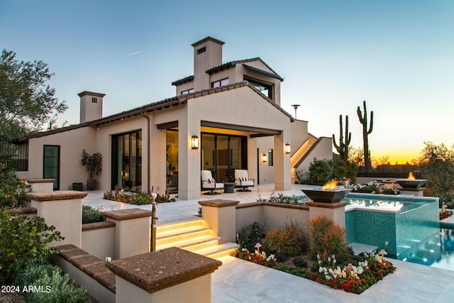 pool at dusk featuring a patio area