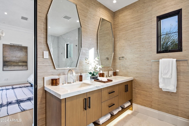 bathroom with tile walls, dual sinks, vanity with extensive cabinet space, tile floors, and ornamental molding