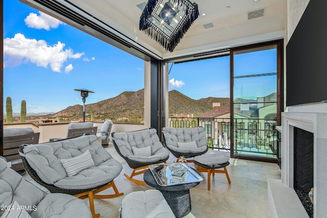 interior space with an outdoor living space, a mountain view, and a balcony