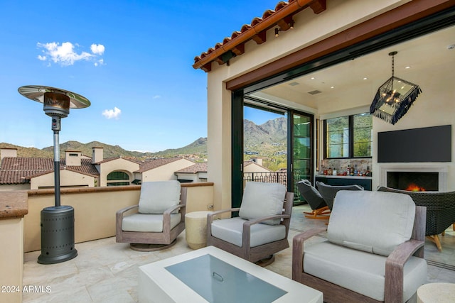 view of patio featuring a mountain view and an outdoor living space with a fireplace