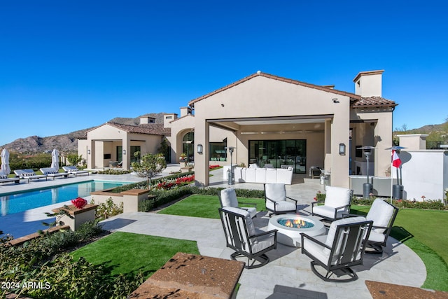 back of house featuring a patio area, an outdoor fire pit, and a lawn