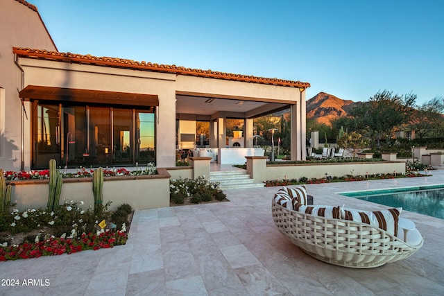 rear view of house with a mountain view and a patio