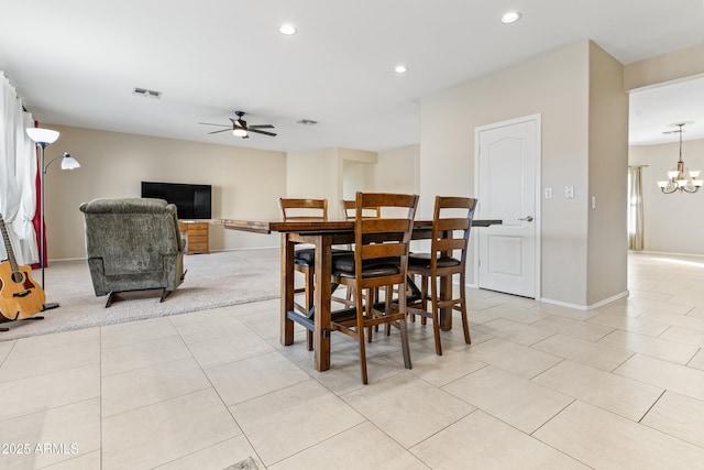 tiled dining area with ceiling fan with notable chandelier