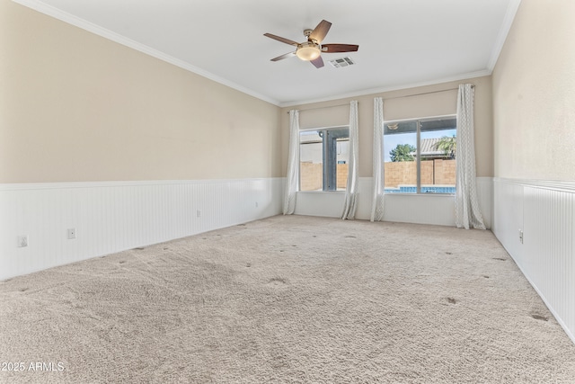 carpeted spare room featuring ornamental molding and ceiling fan