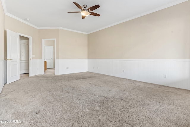 spare room featuring crown molding, light carpet, and ceiling fan