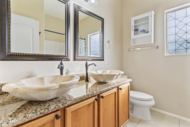 bathroom featuring tile patterned floors, vanity, toilet, and a shower