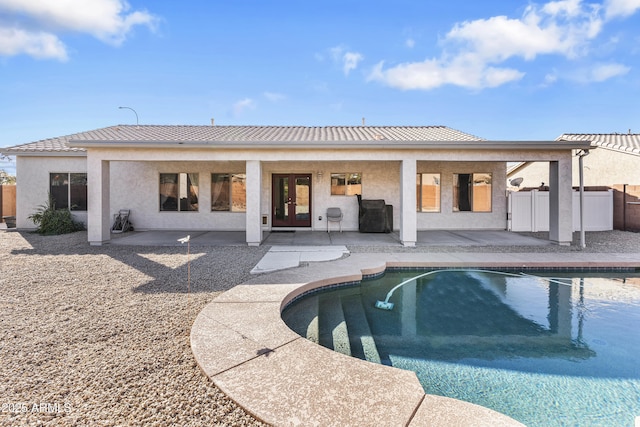 back of house featuring french doors, a fenced in pool, and a patio