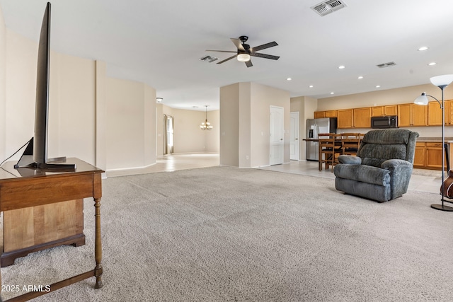 living room featuring light colored carpet and ceiling fan with notable chandelier