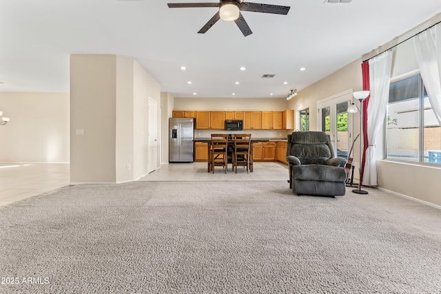 living room featuring light carpet and ceiling fan