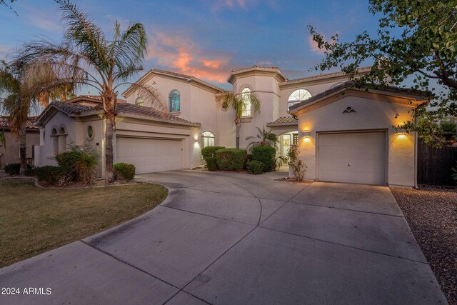 mediterranean / spanish-style home featuring a garage and a lawn