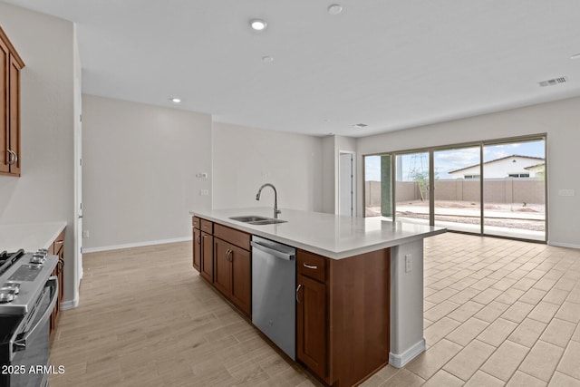 12311 W Parkway Ln, Avondale, AZ 85323 - kitchen featuring stainless steel appliances, a sink, light countertops, baseboards, and a kitchen island with sink