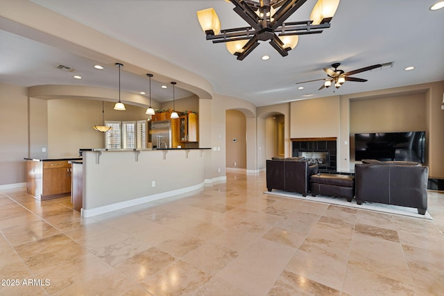 living room with ceiling fan with notable chandelier