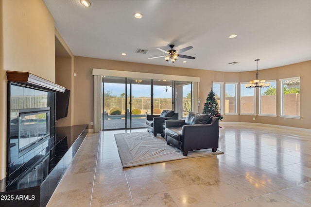 living room featuring ceiling fan with notable chandelier