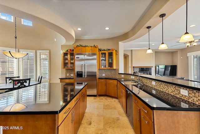 kitchen featuring decorative backsplash, sink, decorative light fixtures, and appliances with stainless steel finishes