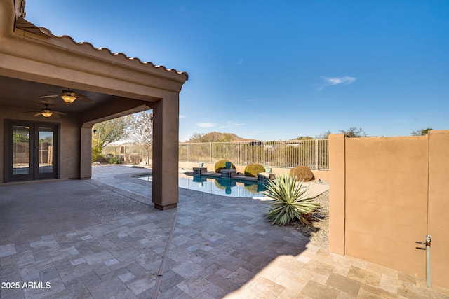 view of patio featuring ceiling fan, a fenced in pool, and french doors