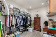 walk in closet with wood finished floors