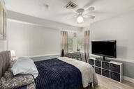 bedroom featuring visible vents, baseboards, wood finished floors, and a ceiling fan