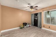 spare room with a ceiling fan and baseboards