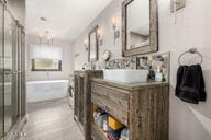 bathroom with vanity, a shower stall, and a bath