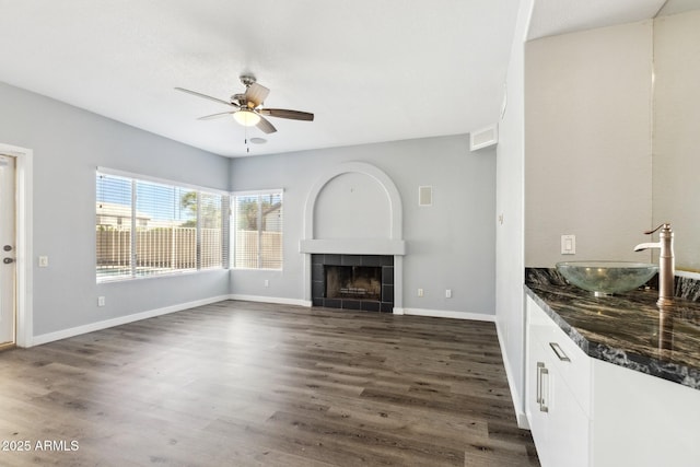3641 E Park Ave, Phoenix, AZ 85044 - unfurnished living room with a sink, ceiling fan, dark wood finished floors, and a fireplace