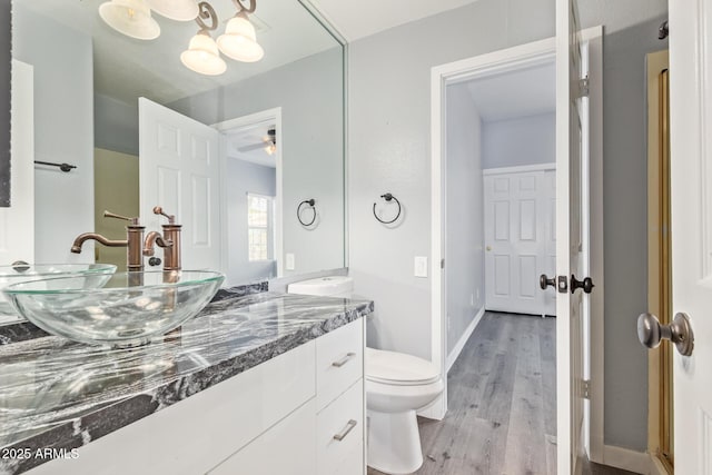 3641 E Park Ave, Phoenix, AZ 85044 - bathroom featuring double vanity, wood finished floors, toilet, baseboards, and ceiling fan