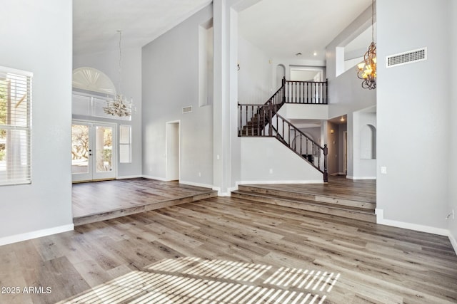 3641 E Park Ave, Phoenix, AZ 85044 - unfurnished living room with high vaulted ceiling, a chandelier, plenty of natural light, wood finished floors, and stairs