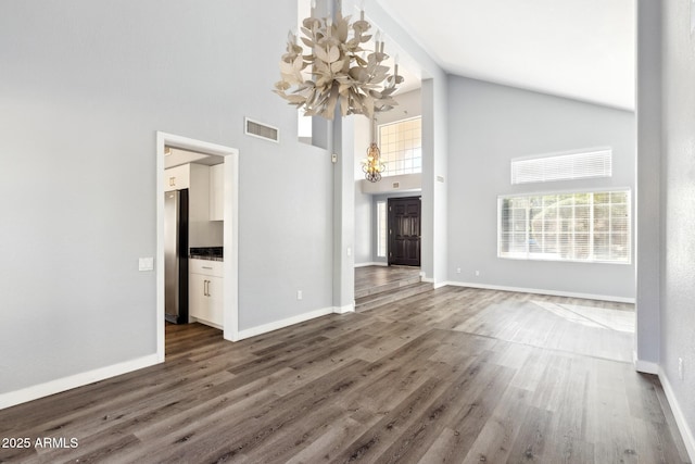 3641 E Park Ave, Phoenix, AZ 85044 - unfurnished living room with a chandelier, high vaulted ceiling, wood finished floors, and baseboards