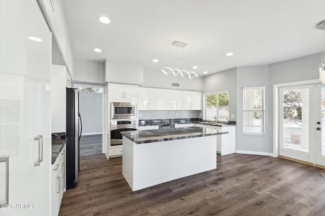 3641 E Park Ave, Phoenix, AZ 85044 - kitchen with stainless steel appliances, a kitchen island, dark wood-style floors, white cabinets, and dark stone counters