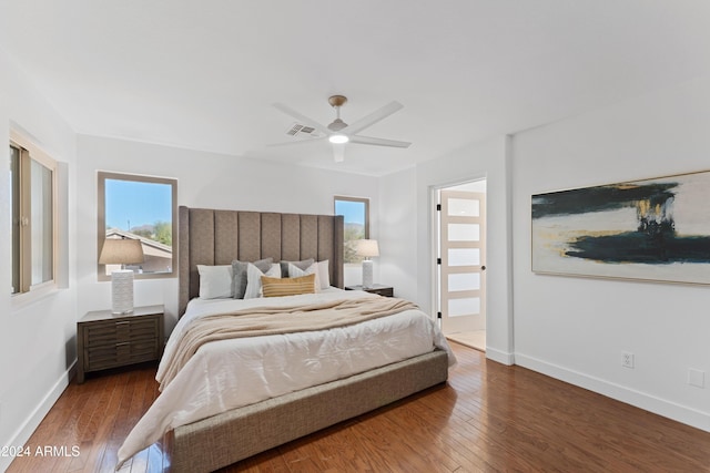 bedroom featuring ceiling fan, ensuite bathroom, and dark wood-type flooring