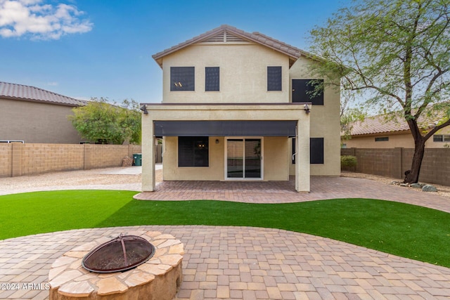 rear view of house featuring a patio and an outdoor fire pit