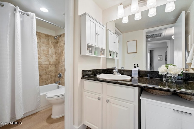 full bathroom with hardwood / wood-style floors, vanity, shower / bath combination with curtain, and toilet