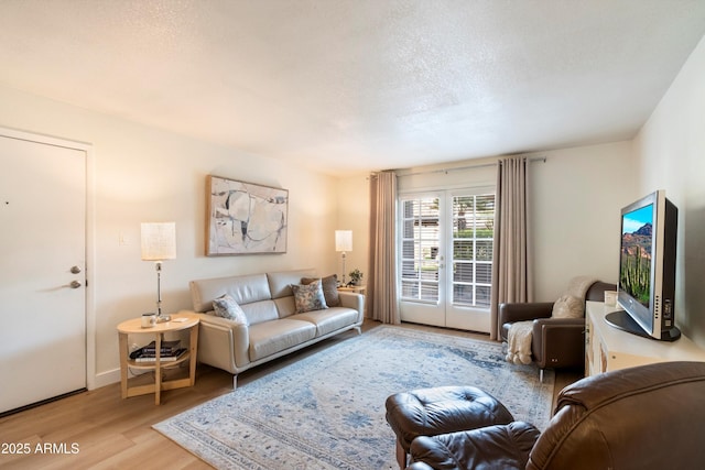 living room with light hardwood / wood-style flooring and a textured ceiling