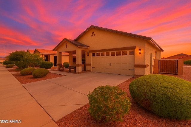22403 W Harrison St, Buckeye, AZ 85326 - ranch-style house featuring driveway, a garage, stucco siding, and a gate