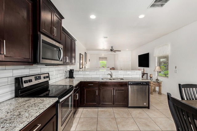 22403 W Harrison St, Buckeye, AZ 85326 - kitchen featuring appliances with stainless steel finishes, a peninsula, ceiling fan, light tile patterned floors, and backsplash