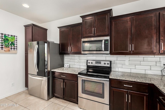 22403 W Harrison St, Buckeye, AZ 85326 - kitchen featuring appliances with stainless steel finishes, decorative backsplash, light tile patterned flooring, and light stone counters