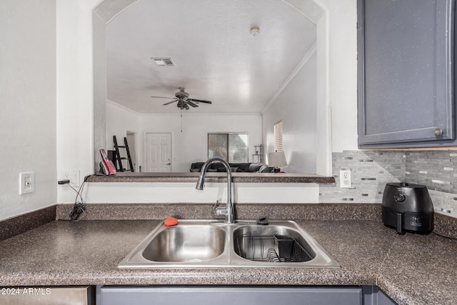 kitchen with backsplash, sink, ceiling fan, gray cabinets, and ornamental molding