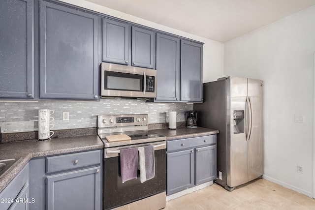 kitchen featuring backsplash, stainless steel appliances, and gray cabinetry