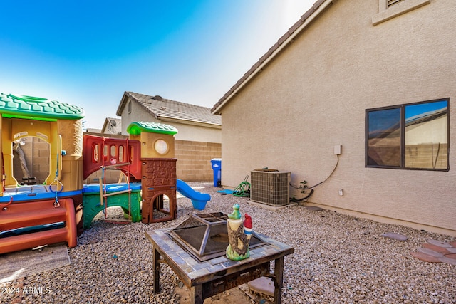 exterior space featuring an outdoor fire pit and cooling unit