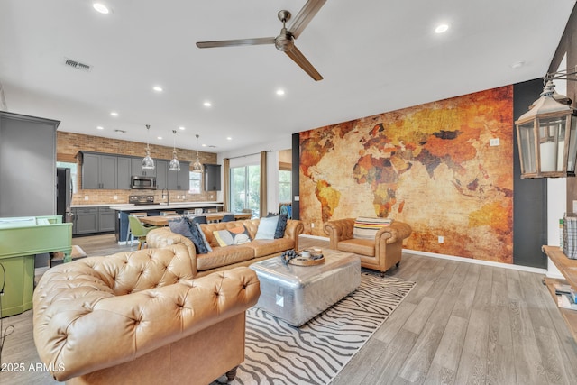 living room featuring ceiling fan and light wood-type flooring