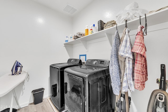 laundry area with wood-type flooring and washer and clothes dryer